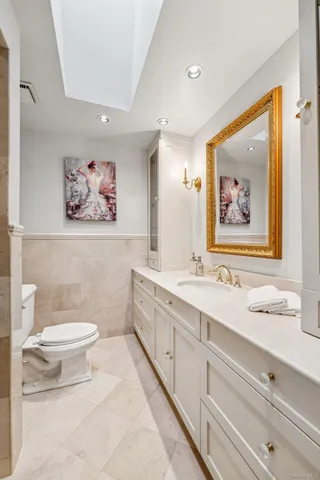 a bathroom with a granite countertop sink and a painting on the wall