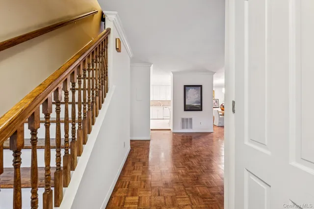 a view of a hallway with wooden floor and staircase