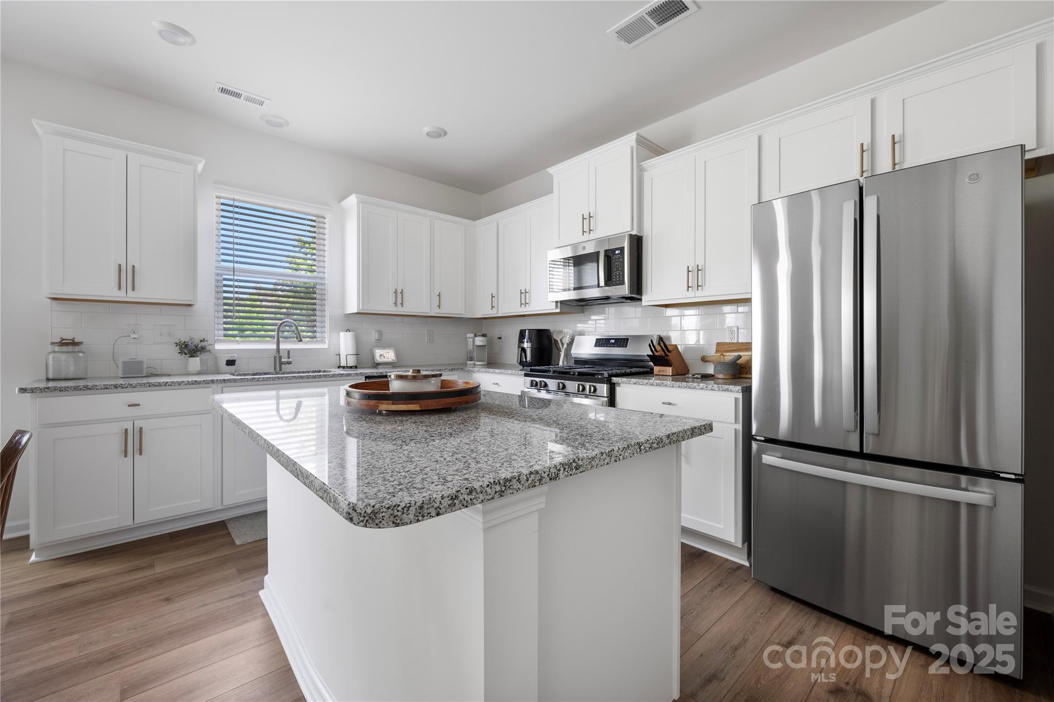 699 Kitfox Drive Northwest Concord, NC 28027 - Photo 1 of 33 a kitchen with granite countertop stainless steel appliances a refrigerator a sink a stove a microwave and cabinets