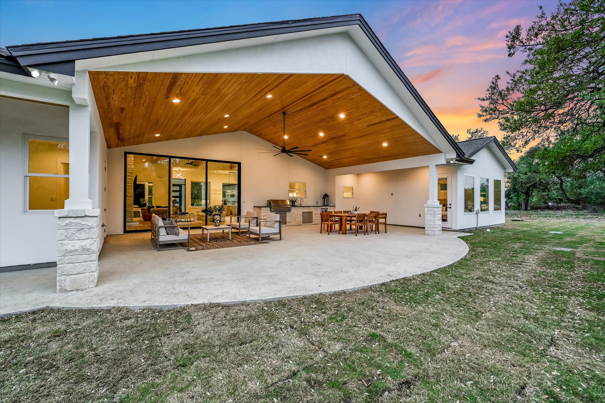 410 Shady Tree Drive Georgetown, TX 78633 - Photo 26 of 40 Back of house at dusk featuring stucco siding, an outdoor kitchen / dining area, a ceiling fan, a patio, and a yard