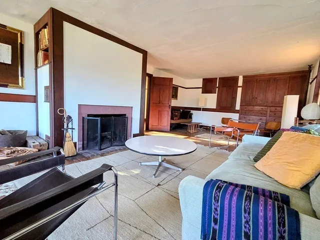 a living room with furniture fireplace and wooden floor