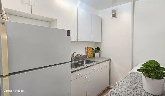 a room with a sink and a refrigerator