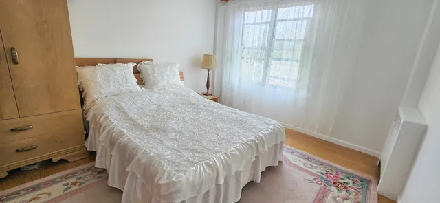 a bed sitting in a bedroom next to a window