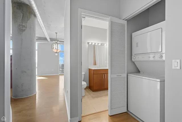 a view of a hallway with bathroom and wooden floor