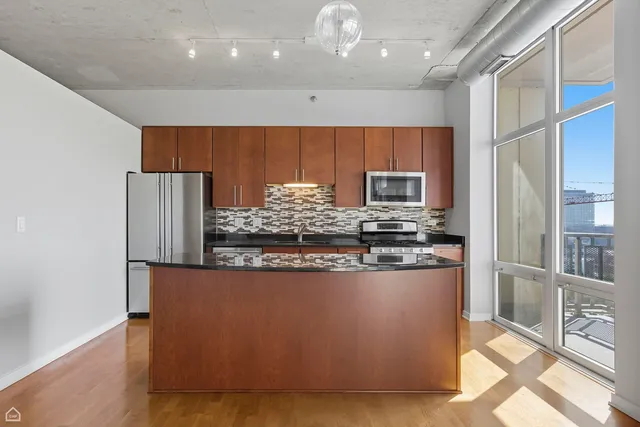a kitchen with stainless steel appliances granite countertop a stove and a refrigerator