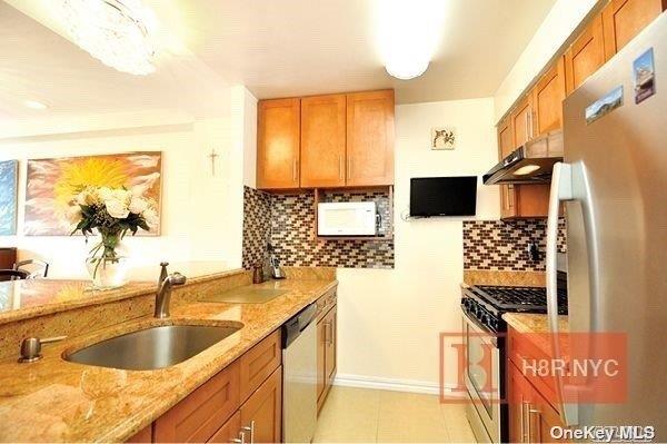 40-40 75th Street, Unit 3J Queens, NY 11373 - Photo 8 of 17 a kitchen with a sink and a refrigerator