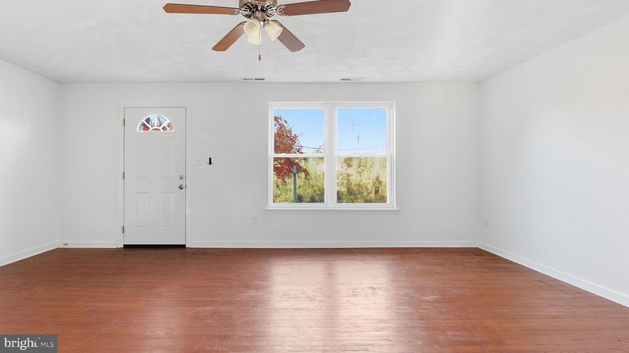 1601 Addison Road South District Heights, MD 20747 - Photo 3 of 21 an empty room with wooden floor chandelier fan and windows