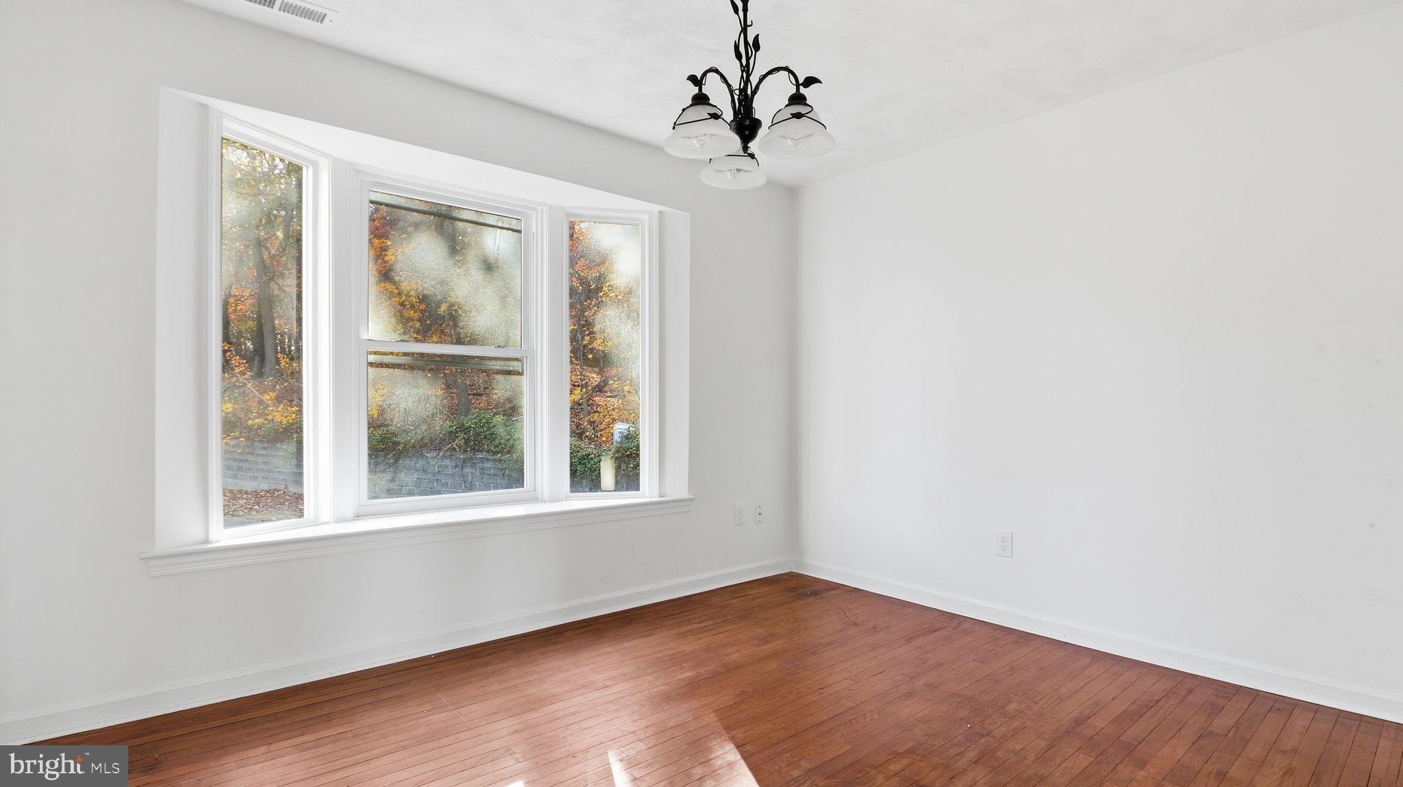 1601 Addison Road South District Heights, MD 20747 - Photo 6 of 21 a view of an empty room with wooden floor and a window