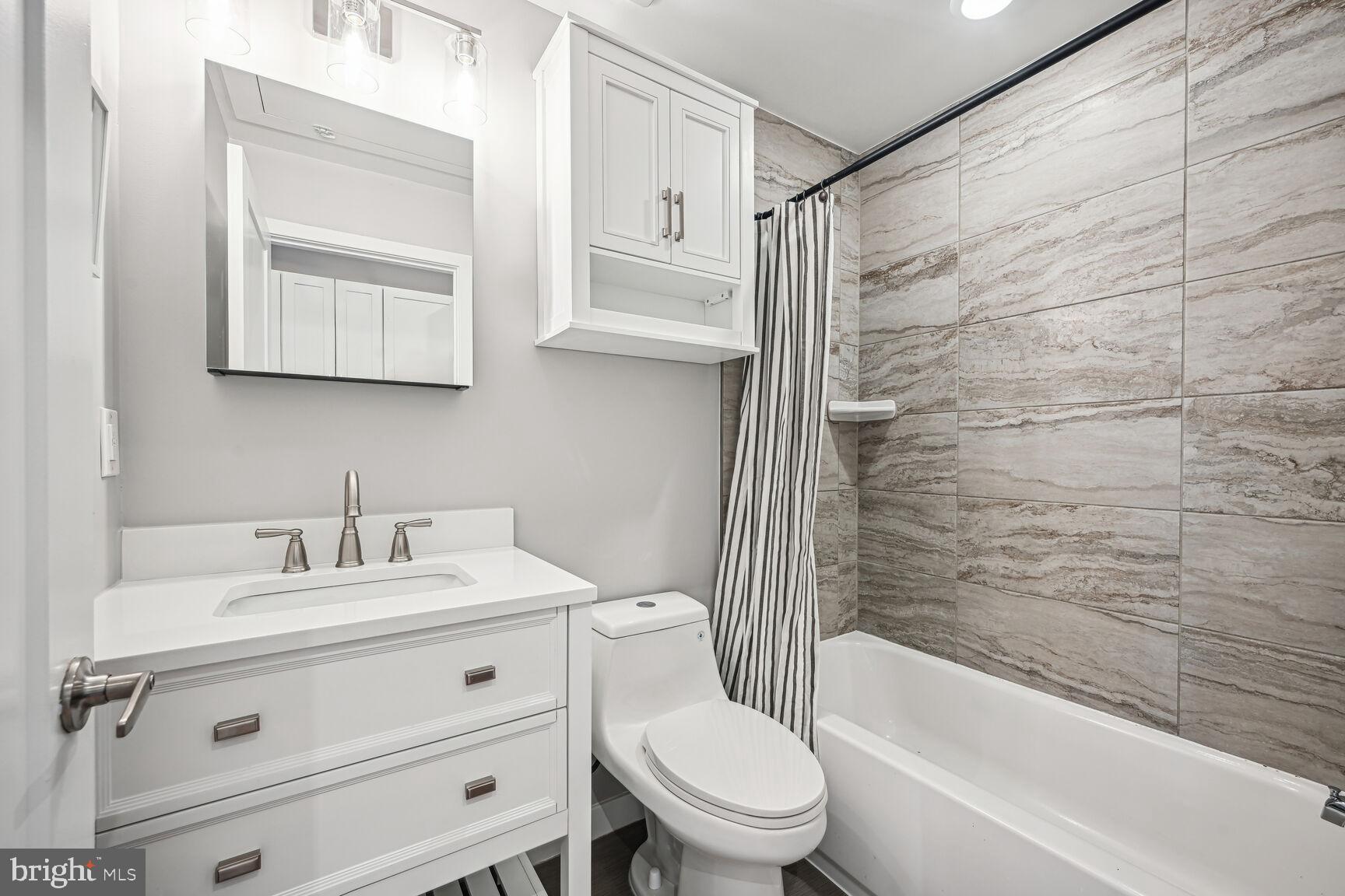 3552 Warder Street Northwest, Unit 1 Washington, DC 20010 - Photo 14 of 21 a bathroom with a sink toilet and shower