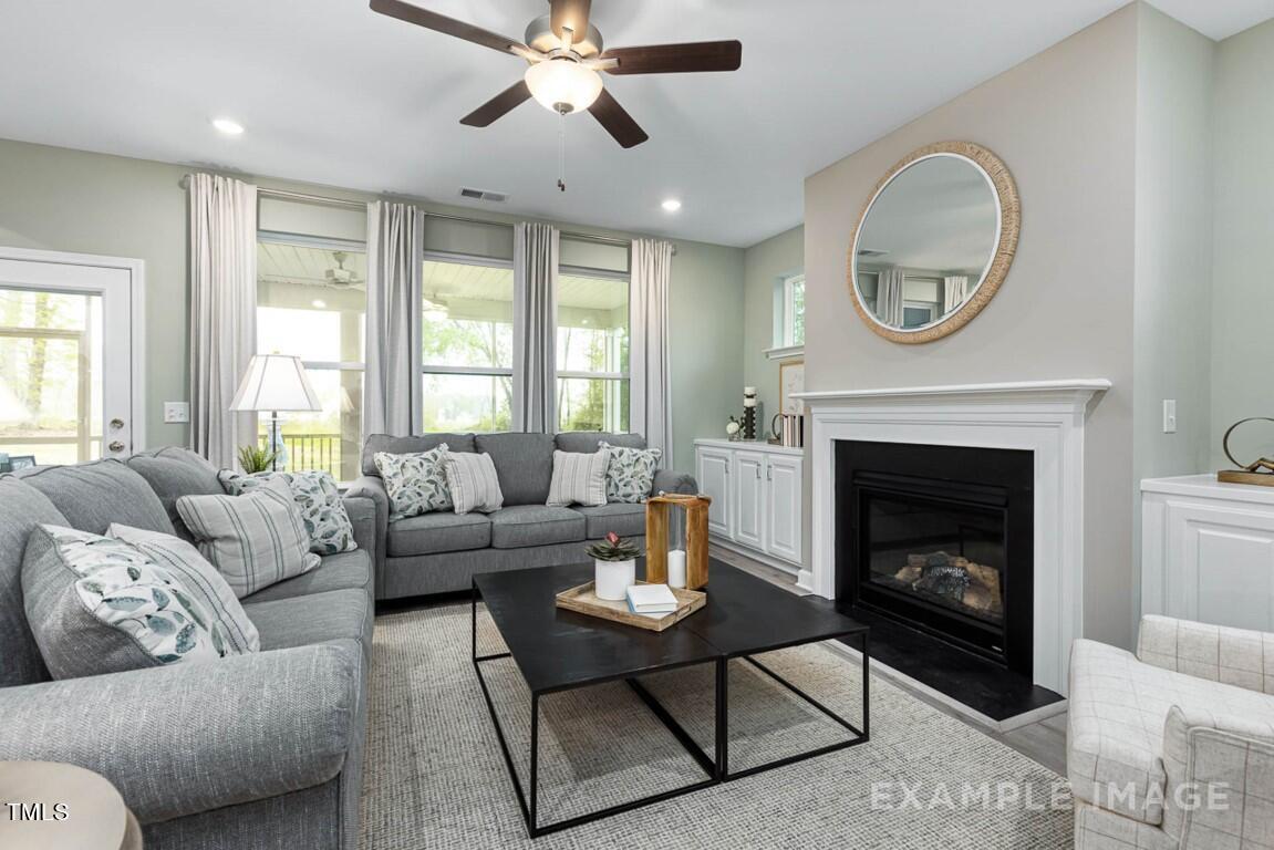 225 Highland Ridge Lane Knightdale, NC 27545 - Photo 14 of 38 a living room with furniture a clock and a fireplace