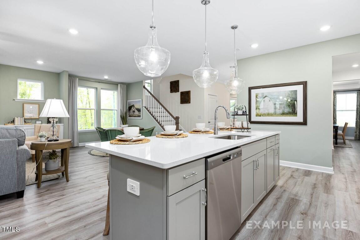 225 Highland Ridge Lane Knightdale, NC 27545 - Photo 15 of 38 a kitchen with a stove a sink a window and chairs