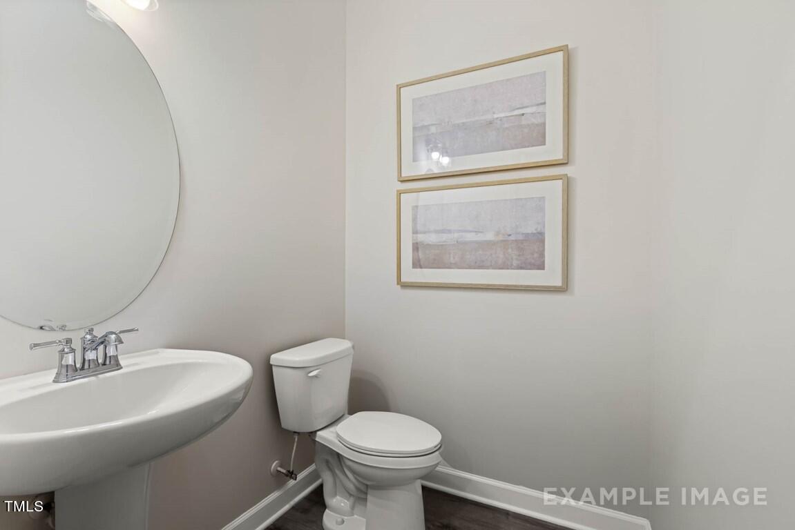 225 Highland Ridge Lane Knightdale, NC 27545 - Photo 20 of 38 a bathroom with a toilet a sink and mirror