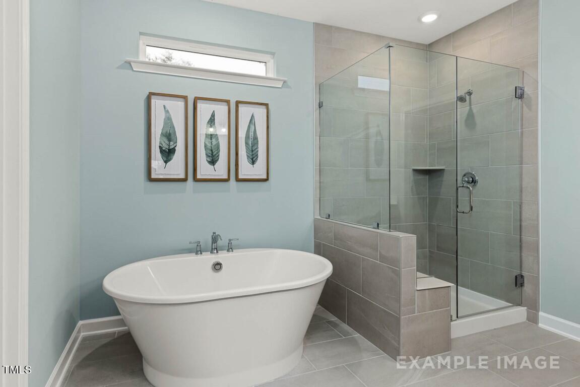 225 Highland Ridge Lane Knightdale, NC 27545 - Photo 26 of 38 a bathroom with a bathtub and shower