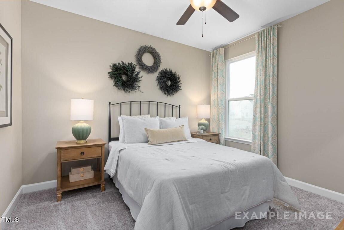 225 Highland Ridge Lane Knightdale, NC 27545 - Photo 30 of 38 a bedroom with a bed a chandelier and a window