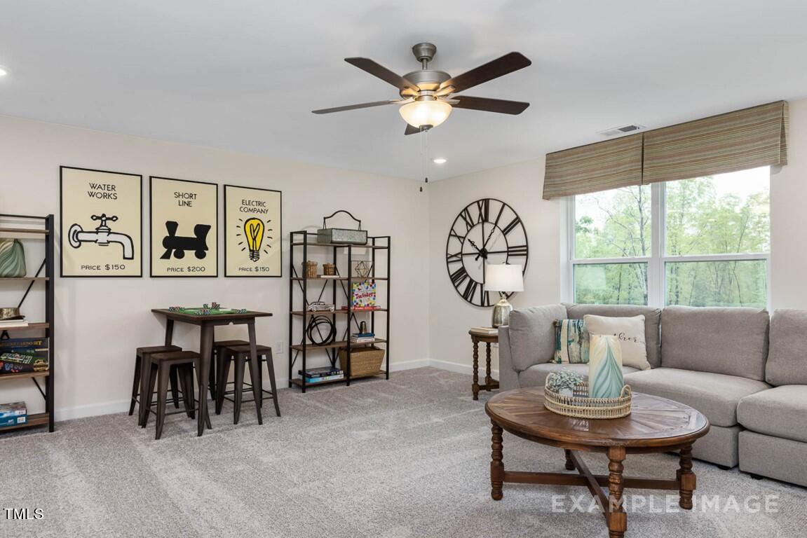 225 Highland Ridge Lane Knightdale, NC 27545 - Photo 33 of 38 a living room with furniture a table and a large window