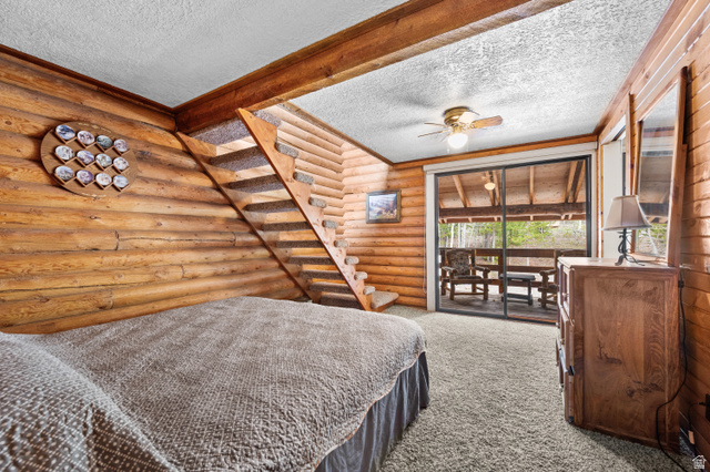 4725 Pine Ridge Road Evanston, UT 82930 - Photo 41 of 82 Wood-paneled room featuring a staircase with carpeted treads, a ceiling fan with integrated lighting, and a sliding glass door leading to an outdoor deck