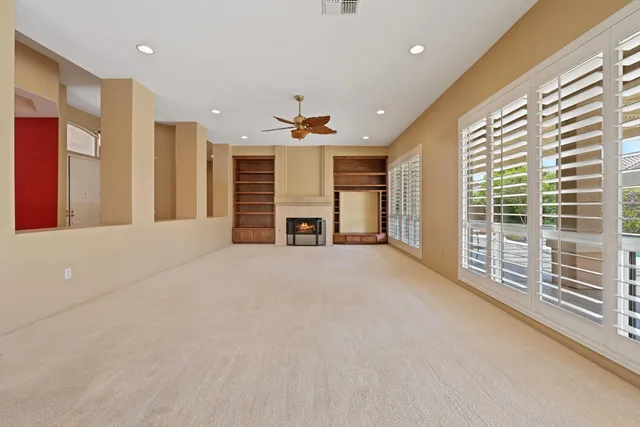 a view of an empty room with a fireplace and a large window