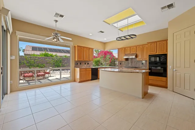 a kitchen with stainless steel appliances kitchen island granite countertop a refrigerator and microwave