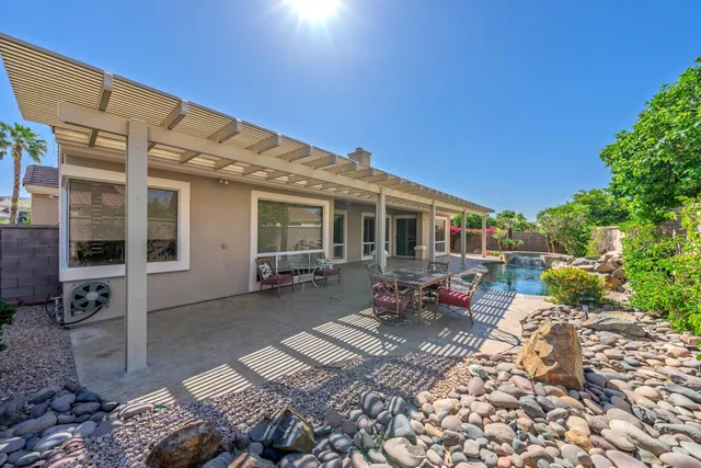 a view of a house with backyard sitting area and garden