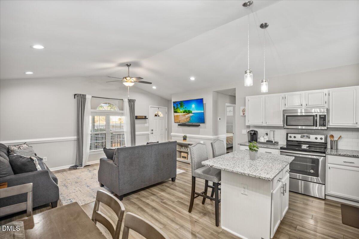 107 Claymont Road Louisburg, NC 27549 - Photo 8 of 30 a living room with stainless steel appliances kitchen island a table and chairs in it