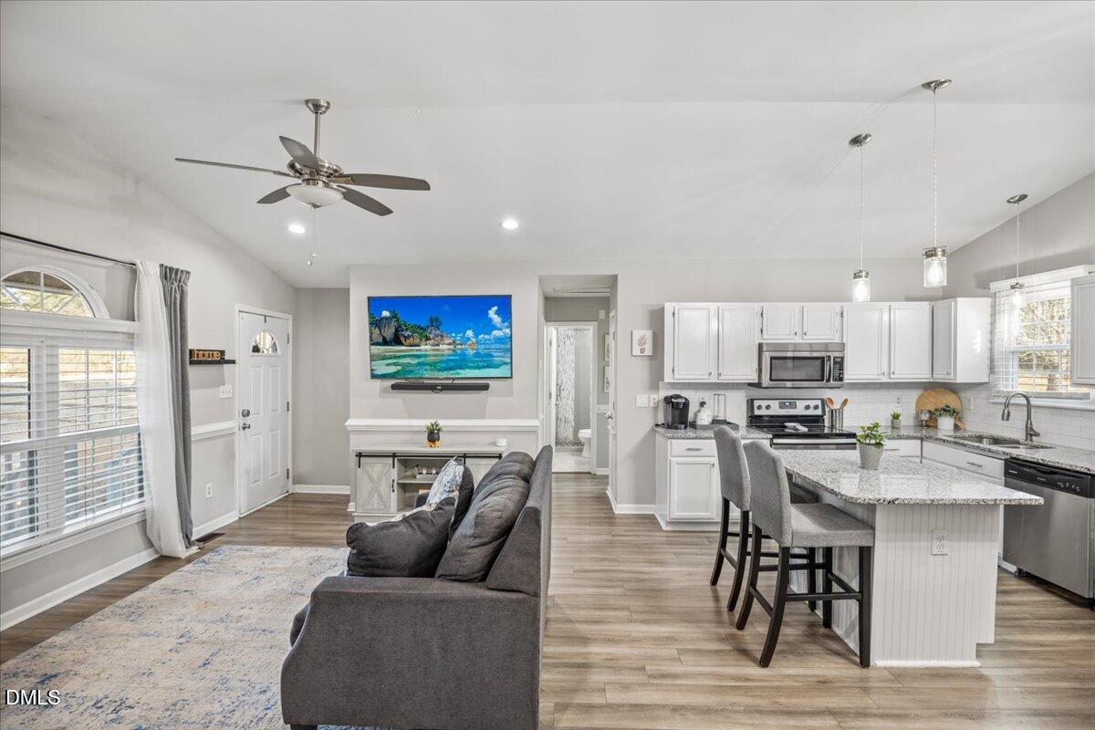 107 Claymont Road Louisburg, NC 27549 - Photo 9 of 30 a living room with furniture kitchen view and a wooden floor
