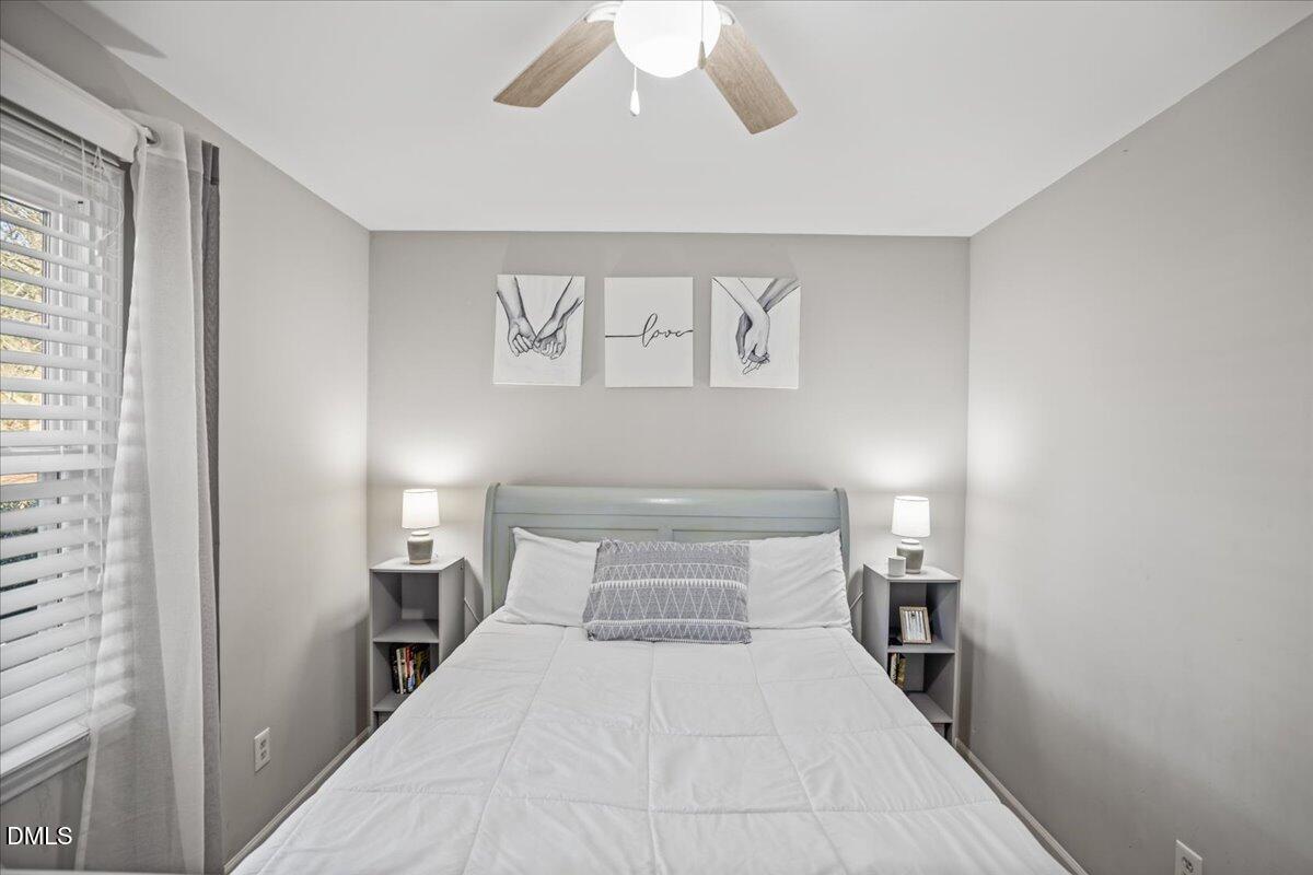 107 Claymont Road Louisburg, NC 27549 - Photo 11 of 30 a bedroom with a large bed and a chandelier