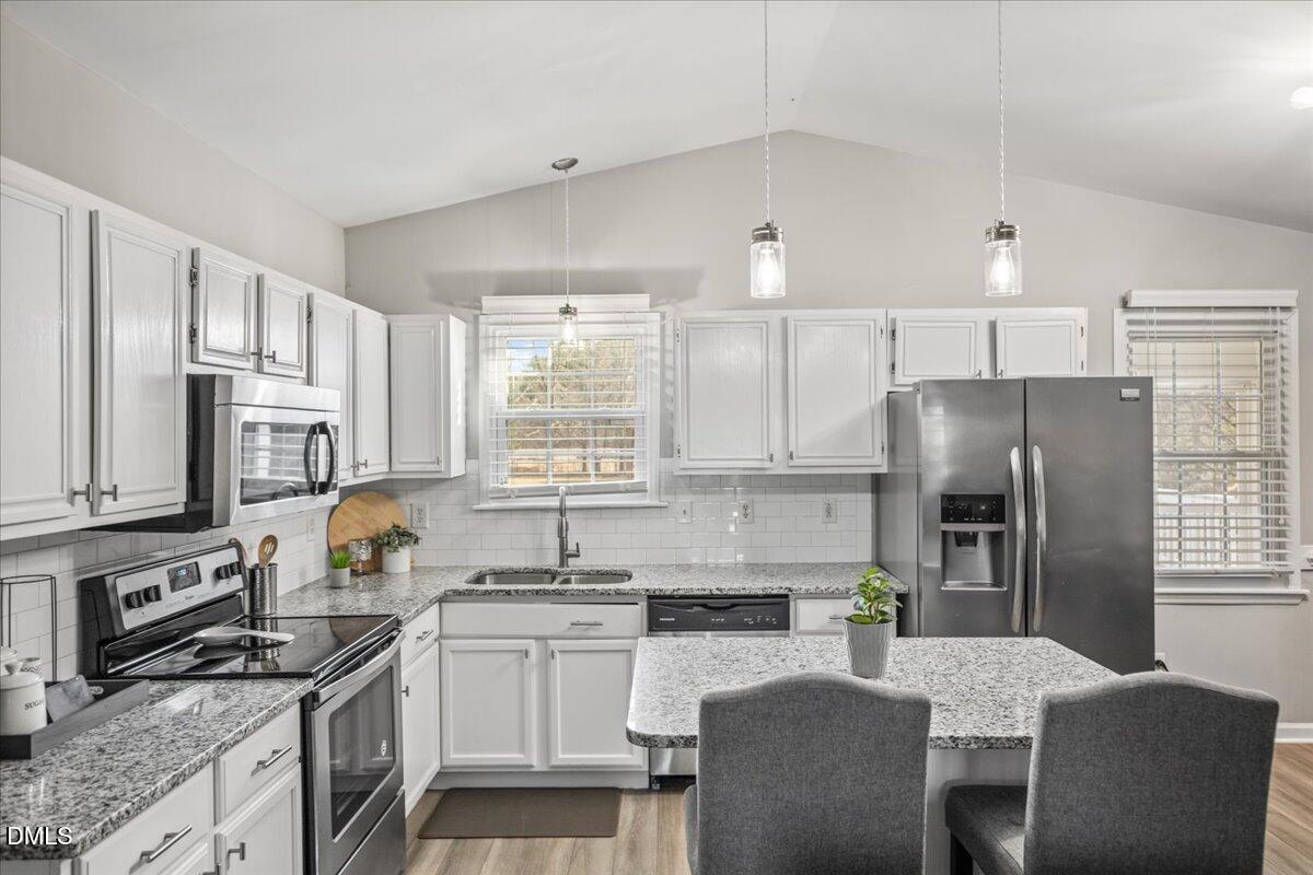 107 Claymont Road Louisburg, NC 27549 - Photo 3 of 30 a kitchen with granite countertop a refrigerator stove microwave and sink