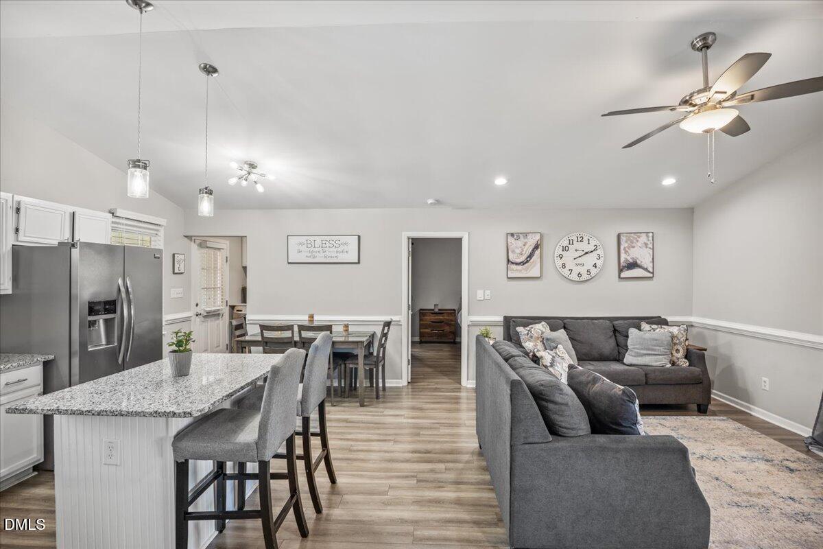 107 Claymont Road Louisburg, NC 27549 - Photo 6 of 30 a living room with furniture kitchen view and a chandelier
