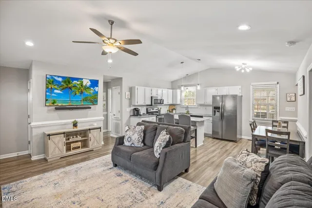 a living room with furniture kitchen view and a chandelier