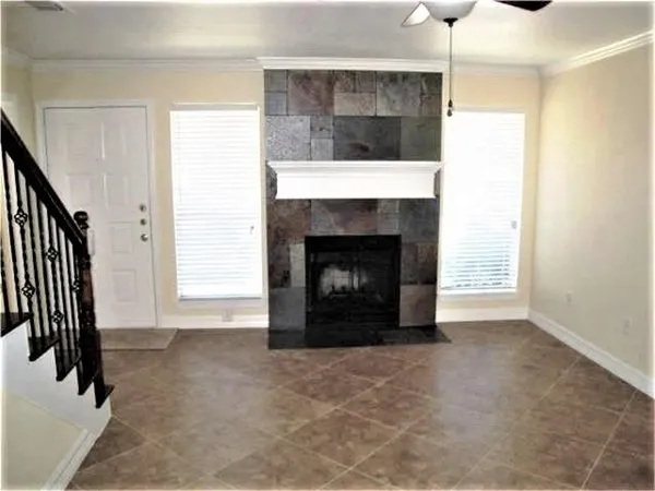 a view of an empty room with fireplace and a window
