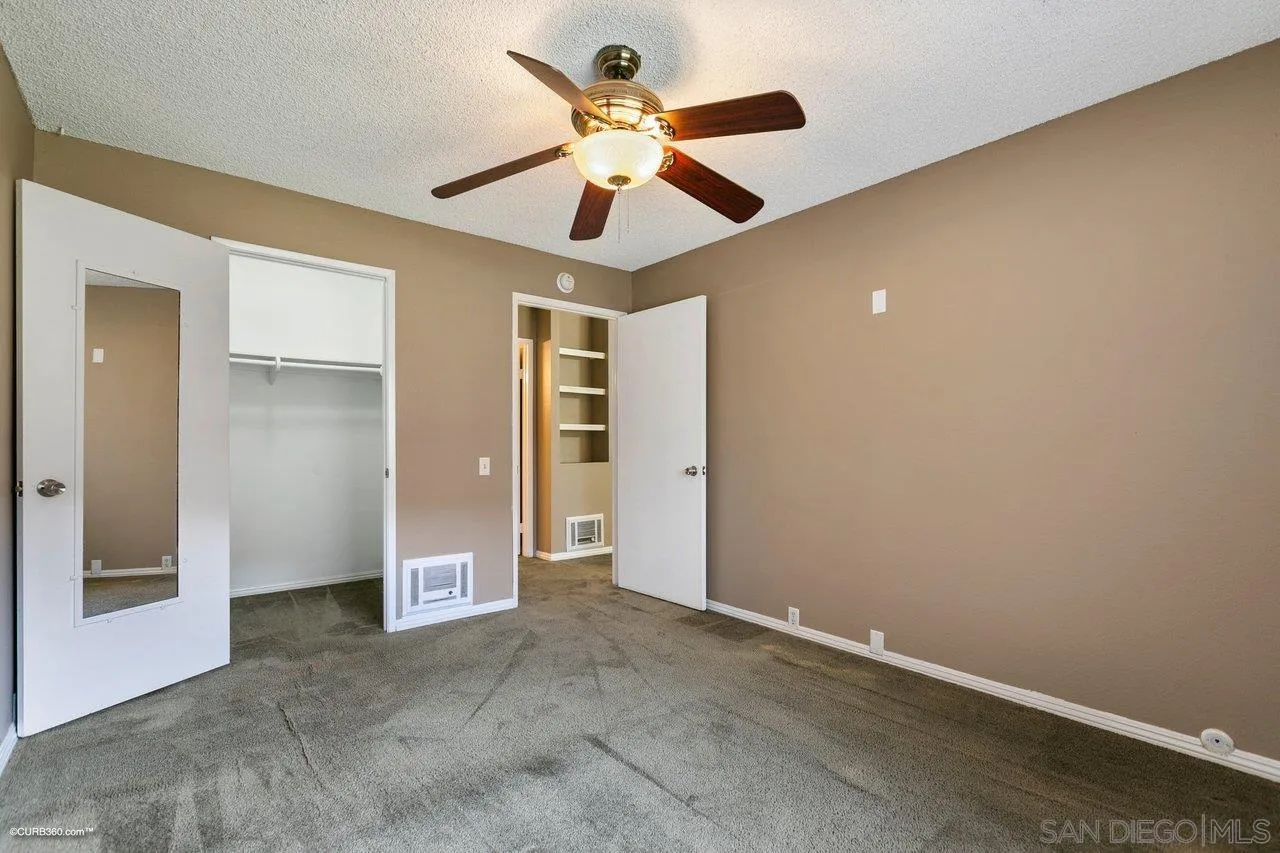 6394 Rancho Mission Road, Unit 106 San Diego, CA 92108 - Photo 11 of 23 an empty room with closet and a ceiling fan
