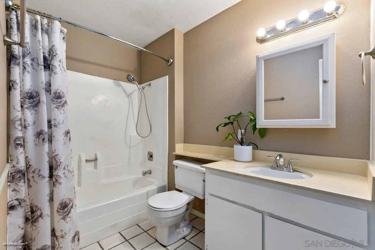 6394 Rancho Mission Road, Unit 106 San Diego, CA 92108 - Photo 14 of 23 a bathroom with a sink toilet a mirror a shower and a bathtub