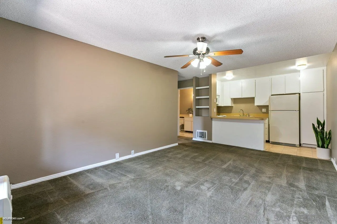 6394 Rancho Mission Road, Unit 106 San Diego, CA 92108 - Photo 4 of 23 a view of a kitchen with a sink and a refrigerator