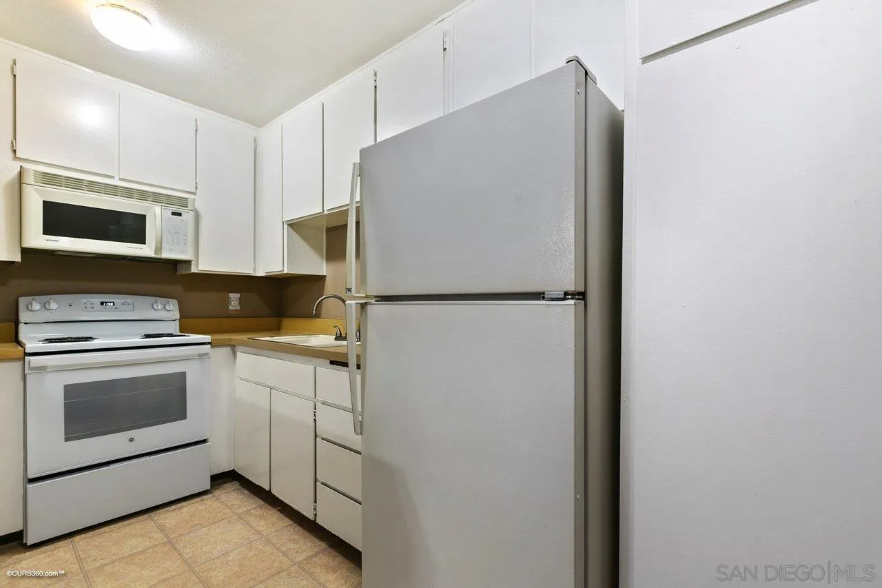6394 Rancho Mission Road, Unit 106 San Diego, CA 92108 - Photo 6 of 23 a kitchen with cabinets and stainless steel appliances
