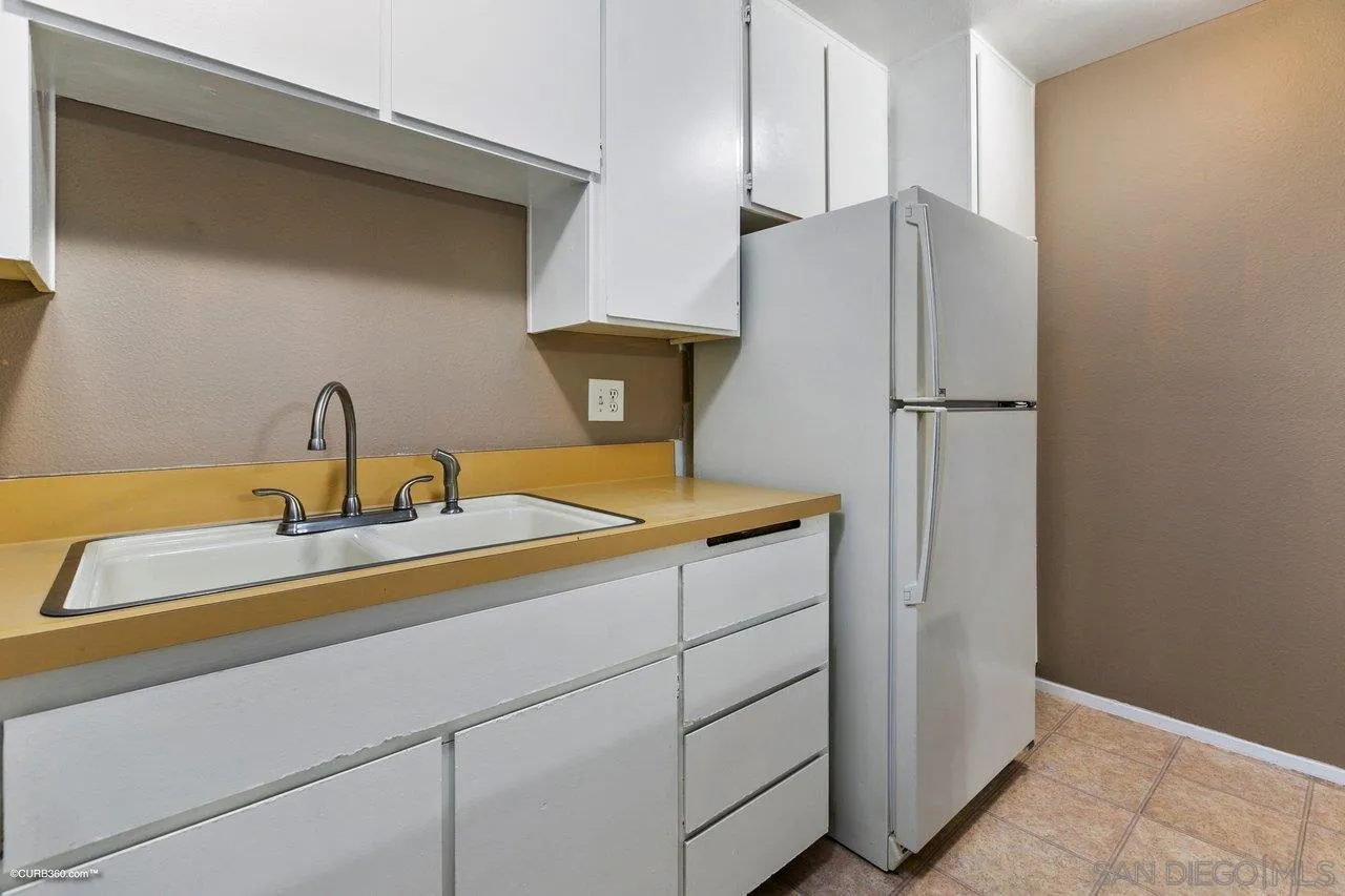 6394 Rancho Mission Road, Unit 106 San Diego, CA 92108 - Photo 7 of 23 a kitchen with a sink and a refrigerator