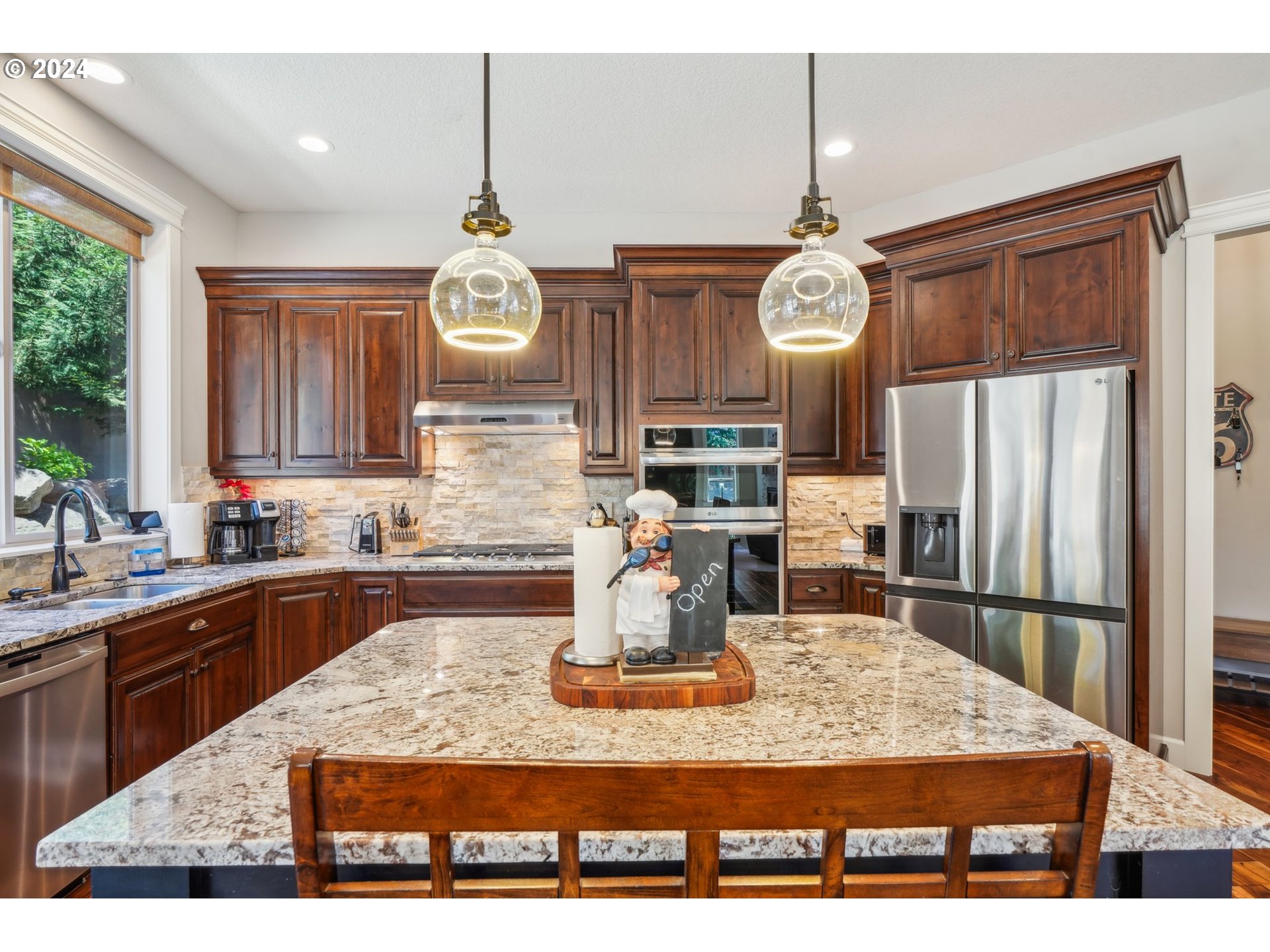 2368 Northwest 17th Avenue Camas, WA 98607 - Photo 15 of 47 a kitchen with kitchen island granite countertop a refrigerator a stove top oven a clock and a window