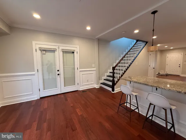 an entryway in wooden floor hall witha front door