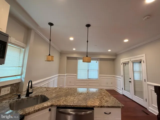 a kitchen with stainless steel appliances granite countertop a sink and a refrigerator