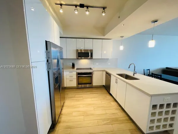 a kitchen with white cabinets and stainless steel appliances