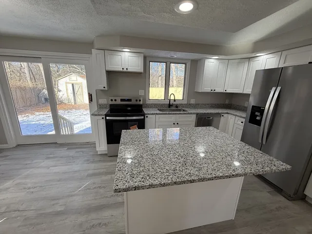 a kitchen with stainless steel appliances granite countertop a sink stove and refrigerator