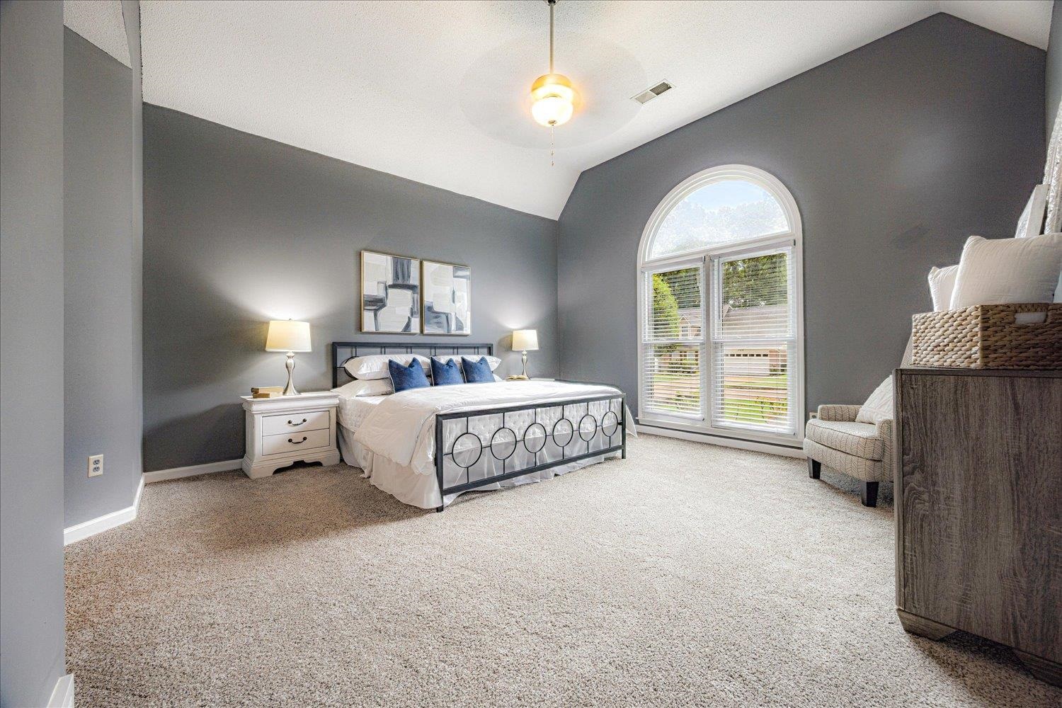 700 Belle Watley Lane Collierville, TN 38017 - Photo 25 of 30 a bedroom with a large bed and a chandelier