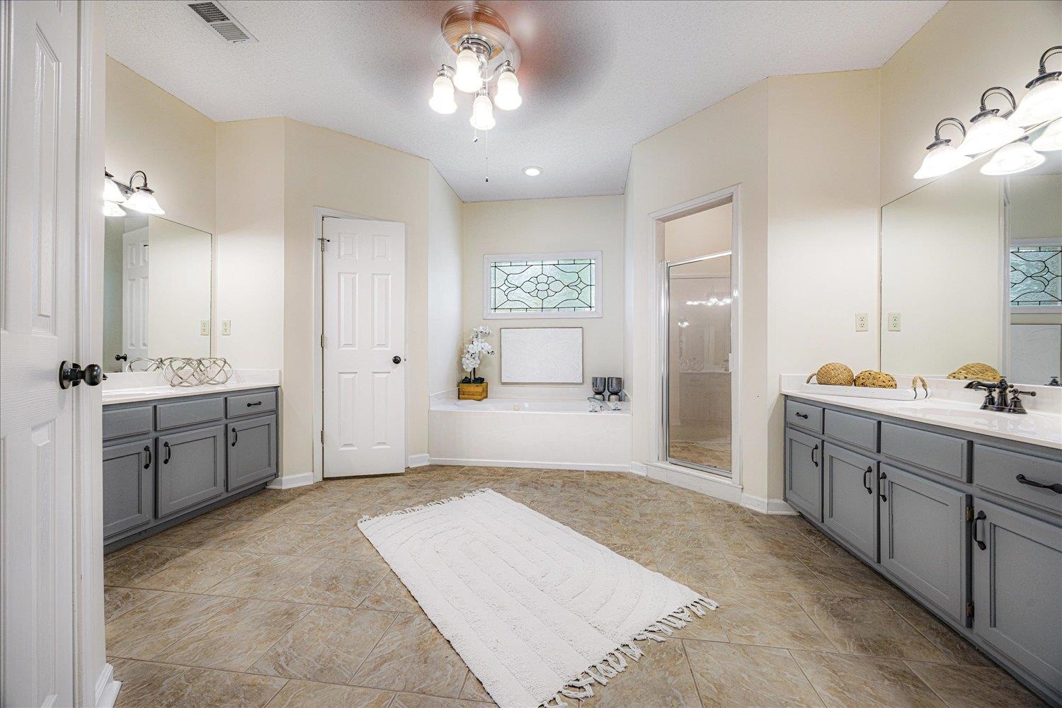 700 Belle Watley Lane Collierville, TN 38017 - Photo 28 of 30 a spacious bathroom with a double vanity sink a mirror a shower and a bathtub