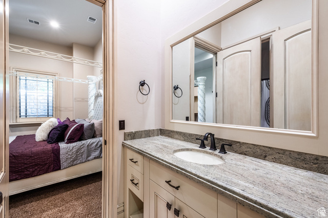 694 West Cephus Road Draper, UT 84020 - Photo 68 of 148 Bathroom vanity featuring a light-toned stone countertop, integrated sink, and matte black faucet