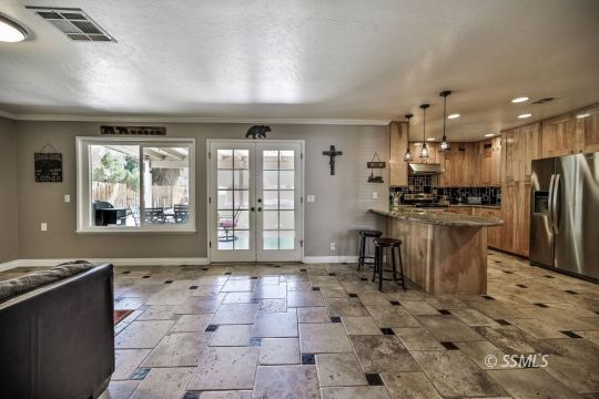 725 West Howell Avenue Ridgecrest, CA 93555 - Photo 20 of 35 a kitchen with stainless steel appliances kitchen island granite countertop a refrigerator and a stove top oven