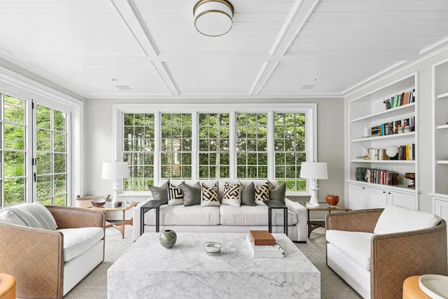 a living room with furniture and large windows