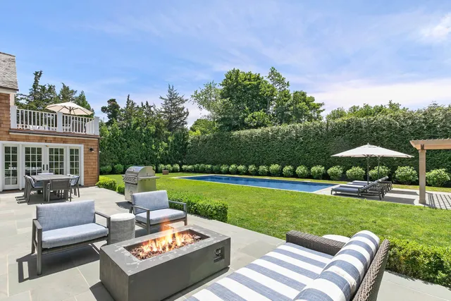a view of a patio with couches chairs and a big yard