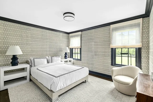 a bedroom with a bed and a large window