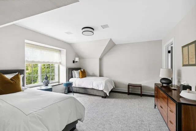 a bedroom with two beds and a large window