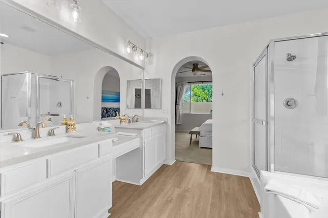 a spacious bathroom with a double vanity sink mirror and shower