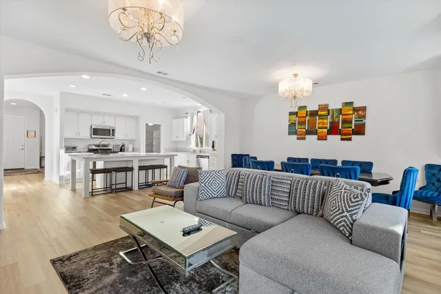 a living room with furniture and a view of kitchen
